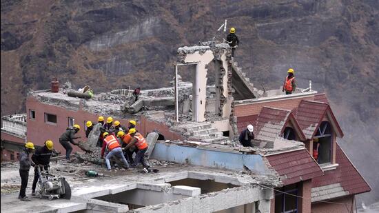 Labourers demolish a building in Joshimath. (AP) Labourers demolish a building in Joshimath. (AP)