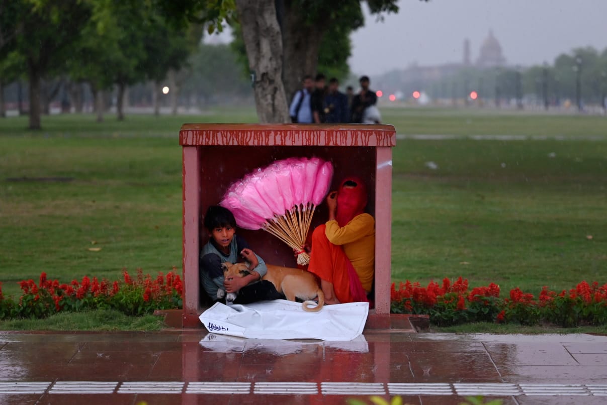 The image shows a kid sheltering his dog from the rain in Delhi.(HT Photo/Vipin Kumar) The image shows a kid sheltering his dog from the rain in Delhi.(HT Photo/Vipin Kumar)