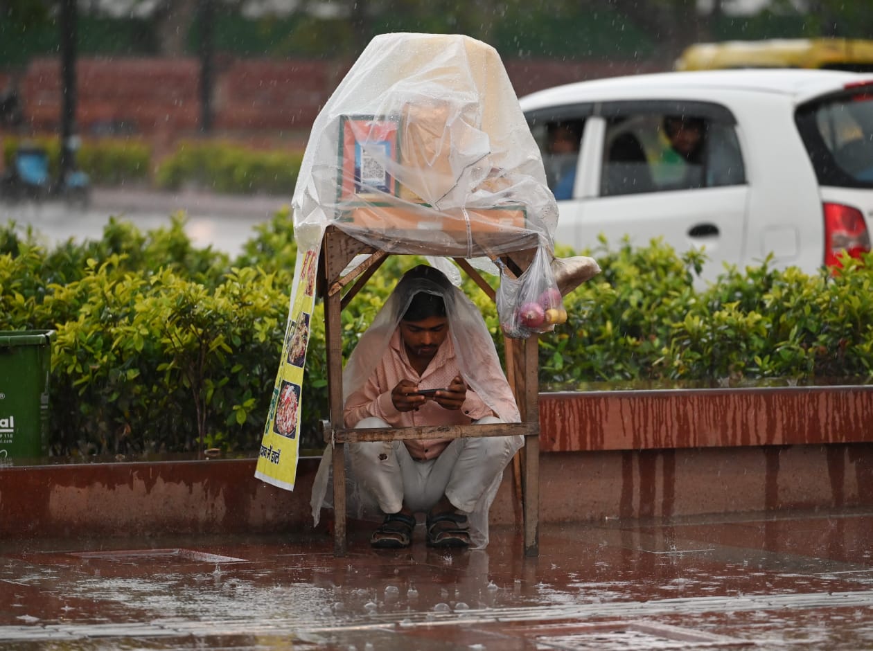A food seller hiding from the rain in Delhi.(HT Photo/Vipin Kumar) A food seller hiding from the rain in Delhi.(HT Photo/Vipin Kumar)