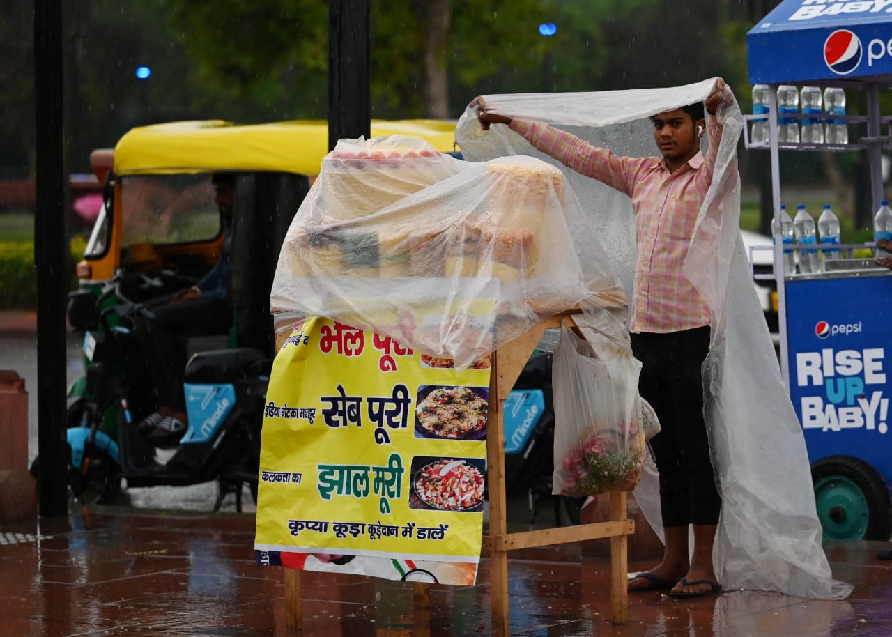 A street vendor sheltering himself from the rain in Delhi.(HT Photo/Vipin Kumar) A street vendor sheltering himself from the rain in Delhi.(HT Photo/Vipin Kumar)