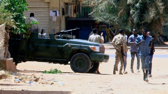 People run past a military vehicle in Khartoum on April 15, 2023, amid reported clashes in the city. - Sudan's paramilitaries said they were in control of several key sites following fighting with the regular army. (AFP) People run past a military vehicle in Khartoum on April 15, 2023, amid reported clashes in the city. - Sudan's paramilitaries said they were in control of several key sites following fighting with the regular army. (AFP)