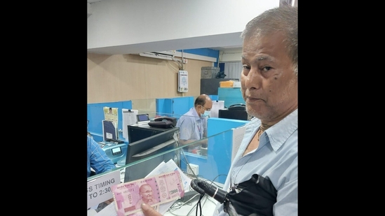 Swapan Kumar Das, 69, a retired central govt employee came to exchange 4 <span class='webrupee'>₹</span>2000 notes at SBI, Kalikapur branch in east Kolkata.(HT Photo)