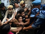 Indian wrestlers Vinesh Phogat (C) with others are detained by the police while attempting to march to India's new parliament.(AFP) Indian wrestlers Vinesh Phogat (C) with others are detained by the police while attempting to march to India's new parliament.(AFP)