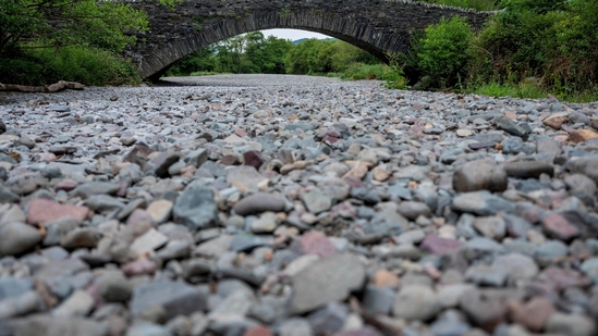 People cross a bridge over the dry river bed,(Reuters)