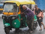 A couple push their auto rickshaw during heavy rains in Ahmedabad, Gujarat. (Reuters) A couple push their auto rickshaw during heavy rains in Ahmedabad, Gujarat. (Reuters)