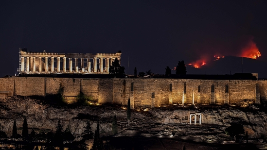 A forest burns behind the Parthenon ancient temple on top of the Acropolis hill as wildfire rages on the outskirts of Athens on August 22.(AFP)
