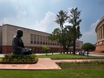 A statue of Mahatma Gandhi sits between the old and new Parliament House buildings on the opening day of the monsoon session of the Indian parliament, in New Delhi, India.(AP) A statue of Mahatma Gandhi sits between the old and new Parliament House buildings on the opening day of the monsoon session of the Indian parliament, in New Delhi, India.(AP)