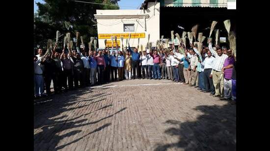 SP Singh (centre) distributing brooms amongst a group of UPSRTC volunteers (HT Photo)
