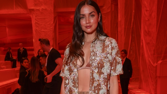 Ana de Armas made heads turn at the Louis Vuitton Spring-Summer show in an embroidered rusted bronze gold outfit featuring a half-sleeved open shirt, silk-satin bralette, and high-waisted straight-fit pants. She styled the ensemble with high heels, an LV handbag, rings, a dainty bracelet, a matching chain, earrings, open tresses, and striking glam picks. (Vianney Le Caer/Invision/AP)