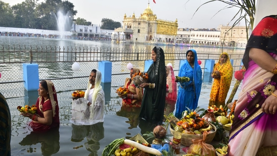Devotees observe Chhath Puja rituals at sunset in a water tank (Sarovar) at Durgiana Temple in Amritsar, Punjab, on Sunday.(Sameer Sehgal/HT Photo)