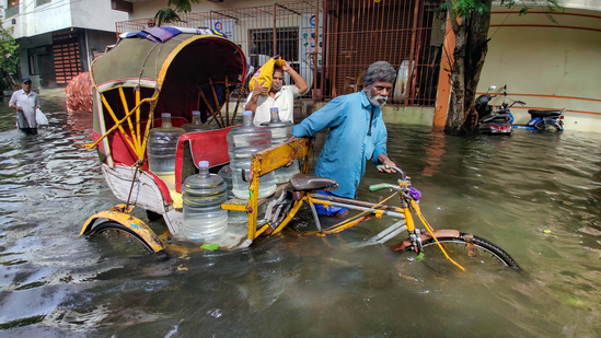 A rickshaw puller wades through flooded road after heavy rainfall owing to Cyclone Michaung in Chennai.(PTI)