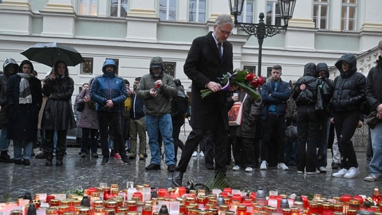 Czech Prime Minister Petr Fiala lays flowers at an impromptu memorial outside Charles University in central Prague. The government announced a day of national mourning, with flags to be flown at half-mast and a minute's silence to be observed at noon on December 23.&nbsp;(AFP)