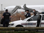 French customs officers stand next to a customs car with an Airbus A340 in the background which was grounded on the tarmac since December 21 over suspected French customs officers stand next to a customs car with an Airbus A340 in the background which was grounded on the tarmac since December 21 over suspected