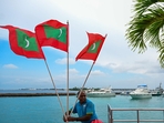 A worker carries national flags of Maldives in Male. (AFP) A worker carries national flags of Maldives in Male. (AFP)