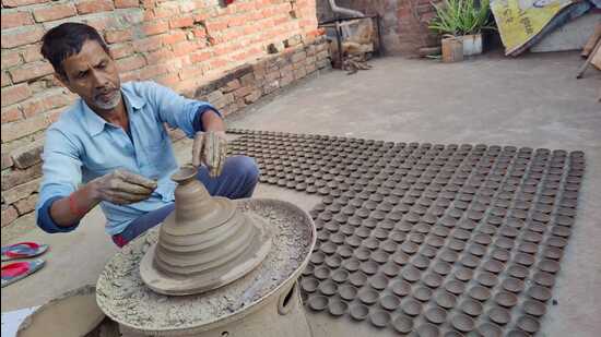 A potter busy making earthen lamps in Prayagraj. (HT Photo) A potter busy making earthen lamps in Prayagraj. (HT Photo)