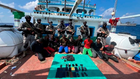 Commandos stand guard with a group of detained pirates after the Indian Navy freed a hijacked fishing vessel. (AP) Commandos stand guard with a group of detained pirates after the Indian Navy freed a hijacked fishing vessel. (AP)
