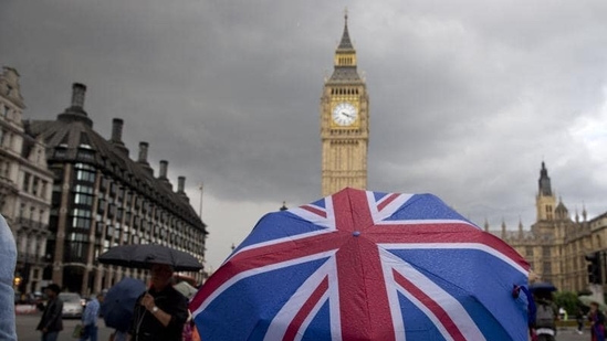A pedestrian shelters from the rain beneath a Union flag themed umbrella.(AFP) A pedestrian shelters from the rain beneath a Union flag themed umbrella.(AFP)