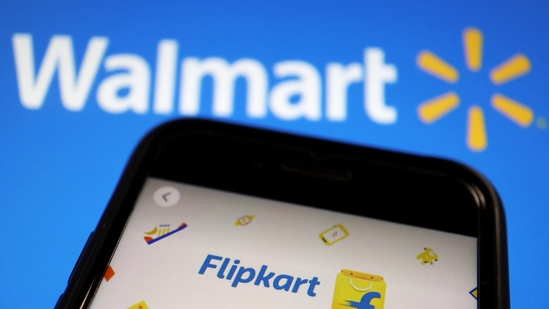 Flipkart valuation: A mobile phone showing an image of Indian online retailer Flipkart is seen in front of a Walmart Inc logo displayed. Flipkart's valuation has declined in the past two years. (Reuters)