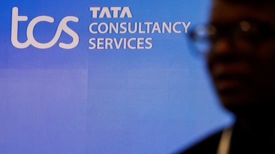 TCS share price: A man walks past a logo of Tata Consultancy Services (TCS) before a press conference.(Reuters)
