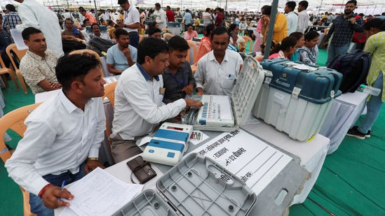 Election staff check the Electronic Voting Machines (EVM) at a polling station ahead of the first phase of polling on Friday.(Reuters)