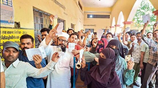 Voters standing in a queue at a polling station to cast their vote during the second phase of the Lok Sabha Polls, in Aligarh on Friday. (HT Photo) Voters standing in a queue at a polling station to cast their vote during the second phase of the Lok Sabha Polls, in Aligarh on Friday. (HT Photo)