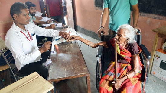 An elderly woman gets her finger ink-marked by a polling officer before voting in Saran, Bihar.(ANI)