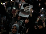 A woman holds up a poster of the late Iranian President Ebrahim Raisi at the mam Khomeini Grand Mosque in Tehran in a funeral ceremony for him and his companions who were killed in a helicopter crash on Sunday in a mountainous region of the country's northwest. (AP) A woman holds up a poster of the late Iranian President Ebrahim Raisi at the mam Khomeini Grand Mosque in Tehran in a funeral ceremony for him and his companions who were killed in a helicopter crash on Sunday in a mountainous region of the country's northwest. (AP)