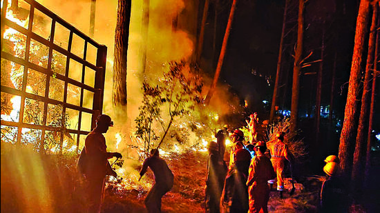 Officials try to douse a fire that erupted in the hills of Varunavat on Wednesday evening. Officials try to douse a fire that erupted in the hills of Varunavat on Wednesday evening.