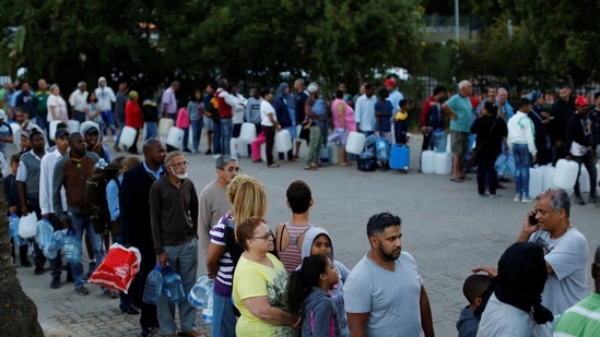 In February 2018, people queuing up to collect water from a spring in the Newlands suburb as the city's water crisis grows in Cape Town, South Africa.(Reuters file) In February 2018, people queuing up to collect water from a spring in the Newlands suburb as the city's water crisis grows in Cape Town, South Africa.(Reuters file)