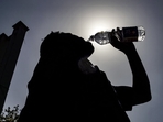 A passenger drinking water is silhouetted against the sun on a hot summer day at Jalandhar Cantonment railway station in Jalandhar on June 11, 2024 amid heatwave. Photo by Shammi MEHRA / AFP) (AFP) A passenger drinking water is silhouetted against the sun on a hot summer day at Jalandhar Cantonment railway station in Jalandhar on June 11, 2024 amid heatwave. Photo by Shammi MEHRA / AFP) (AFP)