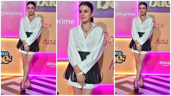 Radhika Madan looked stunning in a white shirt dress paired with a black fringed mini skirt for a touch of flair. She completed her look with stacked necklaces, stud earrings, high heels, and her hair styled in a sleek ponytail.(HT Photo/VarinderChawla)