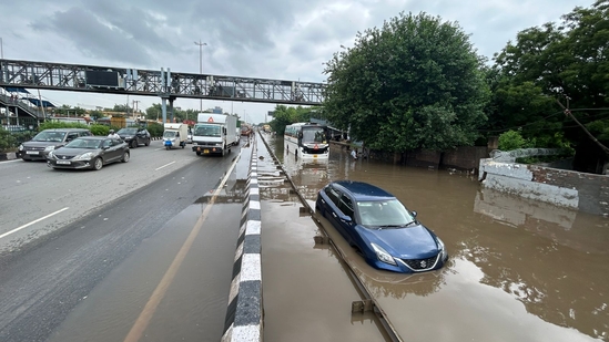 A car and bus are stranded in waterlogged conditions on NH-48 at Narsinghpur Village in Gurugram, highlighting the severe impact of the rain.(Parveen Kumar/HT Photo)