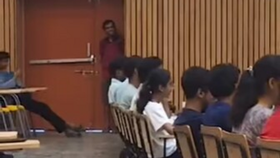 A viral video from IIT Kanpur shows a student sneaking into class late, sparking laughter as the professor jokingly probes the situation. (Instagram/@iit_memecell)