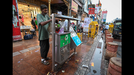 Workers on Tuesday were seen clearing the overflowing garbage bins, but other sanitation work handled by the private contractor would be taken over soon, MCD said. (Sanchit Khanna/HT Photo) Workers on Tuesday were seen clearing the overflowing garbage bins, but other sanitation work handled by the private contractor would be taken over soon, MCD said. (Sanchit Khanna/HT Photo)