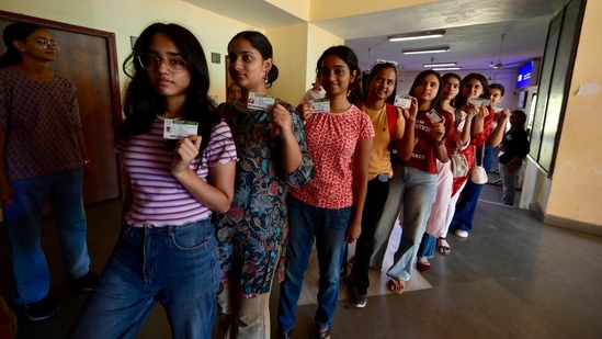 Miranda House, DU students along with their identity cards pose for photographs as they wait to cast their vote during the Delhi University Students Union Elections. (Raj k Raj)