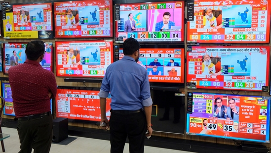 People watch TVs for Haryana results at a showroom, in Gurugram, Tuesday, Oct. 8, 2024. (PTI)