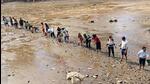Local residents during a drive to rescue fish from the drying water body. (HT ) Local residents during a drive to rescue fish from the drying water body. (HT )