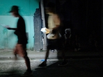 People walk using lights from a car during the second day of the nationwide blackout in Havana October 19, 2024. Hurricane Oscar is due to hit the island of Cuba imminently, with the risk of further affecting the population, who are spending their second night without electricity due to a giant blackout.(Adalberto Roque/AFP) People walk using lights from a car during the second day of the nationwide blackout in Havana October 19, 2024. Hurricane Oscar is due to hit the island of Cuba imminently, with the risk of further affecting the population, who are spending their second night without electricity due to a giant blackout.(Adalberto Roque/AFP)