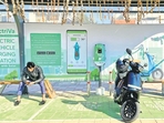 A man checks his mobile phone as he waits while recharging his Ola electric scooter at an electric vehicle charging station in New Delhi. (REUTERS) A man checks his mobile phone as he waits while recharging his Ola electric scooter at an electric vehicle charging station in New Delhi. (REUTERS)