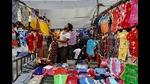 A man arranges clothes at his shop in a wholesale market in Dhaka on September 30, 2024. (Photo by Munir Uz Zaman / AFP) (AFP) A man arranges clothes at his shop in a wholesale market in Dhaka on September 30, 2024. (Photo by Munir Uz Zaman / AFP) (AFP)