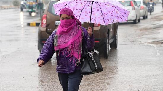 A woman makes her way through puddled roads in Chandigarh on Monday. (kESHAV SINGH/HT) A woman makes her way through puddled roads in Chandigarh on Monday. (kESHAV SINGH/HT)
