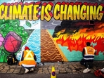 Street artists paint a mural on climate change. (AFP File Photo) Street artists paint a mural on climate change. (AFP File Photo)