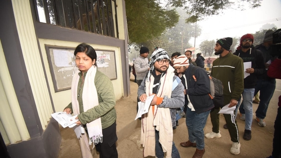 Applicants waiting in a queue outside examination center before entering an examination center to appear for the Bihar Public Service Commission (BPSC) 70th Prelims Exam, at Bankipur Girls High School, in Patna. (Santosh Kumar )