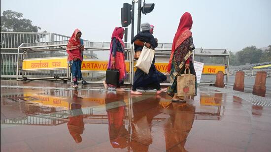 Workers navigate a waterlogged pavement at Kartavya Path. (Vipin Kumar/HT Photo) Workers navigate a waterlogged pavement at Kartavya Path. (Vipin Kumar/HT Photo)