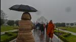 Visitors enjoy the cold and rain at the Lotus Temple in New Delhi Saturday evening. (RAJ K RAJ /HT PHOTO) Visitors enjoy the cold and rain at the Lotus Temple in New Delhi Saturday evening. (RAJ K RAJ /HT PHOTO)