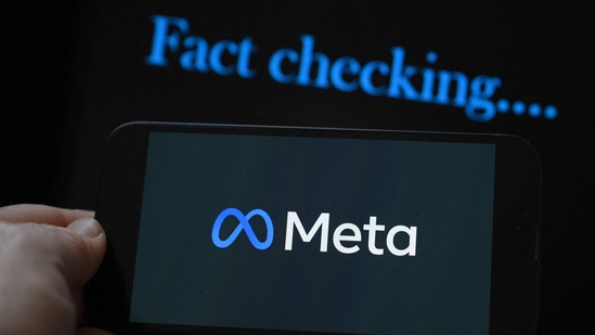 This photo illustration created on January 8, 2025, in Brussels, shows the media giant Meta's logo displayed on a smartphone and screen displaying the words "fact checking". (Photo by Nicolas TUCAT / AFP)(AFP) This photo illustration created on January 8, 2025, in Brussels, shows the media giant Meta's logo displayed on a smartphone and screen displaying the words "fact checking". (Photo by Nicolas TUCAT / AFP)(AFP)
