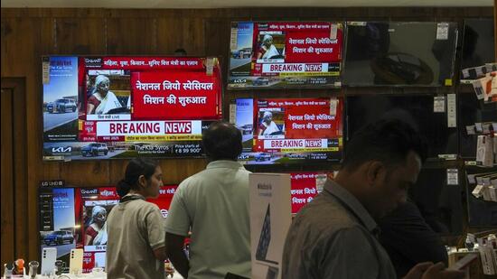 People watch a live telecast of the presentation of the ‘Union Budget 2025-26’ on televisions at a showroom in Mumbai on Saturday. (PTI) People watch a live telecast of the presentation of the ‘Union Budget 2025-26’ on televisions at a showroom in Mumbai on Saturday. (PTI)