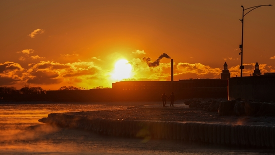 A couple take a walk at sunrise near the icy Oak Street Beach along the shore of Lake Michigan Monday, Jan. 20, 2025, in Chicago (AP/Kiichiro Sato) A couple take a walk at sunrise near the icy Oak Street Beach along the shore of Lake Michigan Monday, Jan. 20, 2025, in Chicago (AP/Kiichiro Sato)