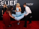Staff arranges the dress of Sabrina Carpenter at the red carpet.(REUTERS)