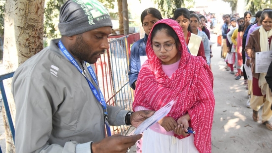 Officials checking the admit card details of candidates out the examination centre. (Santosh Kumar)